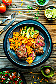 Steak with sweet potato chips and roasted avocado