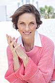 Woman in a pink sweater and white shirt on the beach