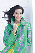 Mature, dark-haired woman in a green coat