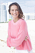 Happy, long-haired woman in pink jumper