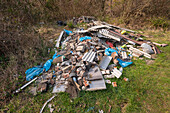 Asbestos sheets in fly tipped material on wasteland