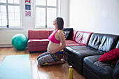 Pregnant woman exercising on living room floor