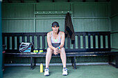 Pregnant woman resting on tennis bench