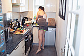 Pregnant woman making lunch in apartment kitchen