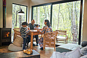 Family playing game at cabin table in woods