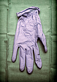 Glove of latex blue on green cloth in an operating theatre