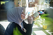 Female Muslim artist in hijab painting ceramic mug