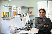 Female seamstress in hijab at sewing machine