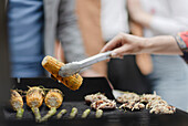 Close up woman barbecuing corn on barbecue grill