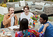 Couple friends talking and enjoying lunch at patio table