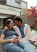 Affectionate pregnant woman and partner on patio