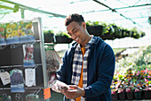 Smiling man shopping for plant seeds in garden shop