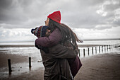 Happy affectionate couple hugging on wet winter beach