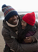 Happy carefree couple in warm clothing hugging