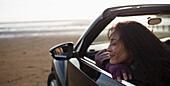 Woman in convertible on beach
