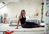 Confident woman stretching on bedroom floor