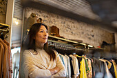 Thoughtful female shop owner in clothing boutique