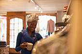 Portrait happy female shop owner in clothing boutique