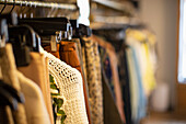 Clothes hanging on racks in clothing boutique