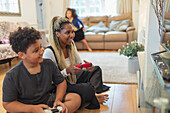 Mother and son playing video game on living room floor