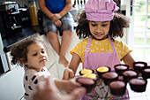 Girls baking cupcakes in kitchen