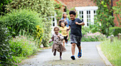 Happy brother and sister running in driveway