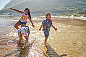 Sisters and brother with Down Syndrome playing on beach