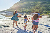 Happy family running on sunny summer beach