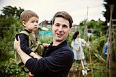 Happy father and toddler son on allotment