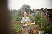 Smiling woman harvesting vegetables