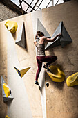 Young woman on climbing wall