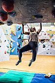 Female rock climber hanging from climbing wall