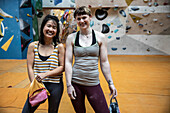 Happy female rock climbers at climbing center