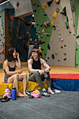 Happy female rock climber friends preparing at climbing gym