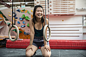 Happy female rock climber training in climbing gym
