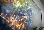 Woman with headphones on courtyard with reflections