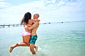 Couple playing in sunny ocean