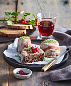 Game pâté wrapped in bacon with cranberries