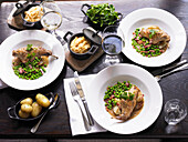 Braised rabbit with grain mustard sauce, Jersey Royals, peas and bacon