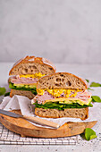 Ciabata-Sandwich mit Spinat, Gurke, Schinken, Käse und Rührei
