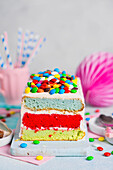 Rainbow sponge cake with chocolate colored dragees