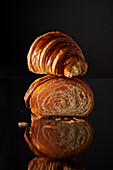 Halbiertes Croissant vor schwarzem Hintergrund