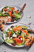 Rocket salad with cucumber, salmon, feta and olives