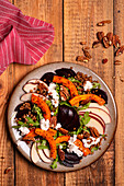 Salad with red sorghum beetroot apple arugula roasted pumpkin pecans