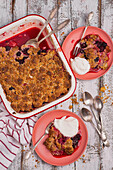 Strawberry and blackberry cobbler with streusel topping, served with yogurt