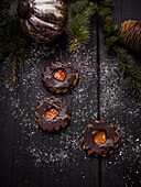 Spitzbuben mit Aprikosenmarmelade und Schokoglasur auf dunklem Holzuntergrund