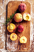 Peaches and nectarines with rosemary on a wooden board