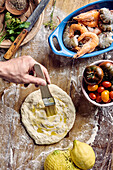 Prepare pinsa with prawns and tomatoes - Brush the pinsa pastry with oil