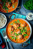 Meatballs in curry sauce with green peas