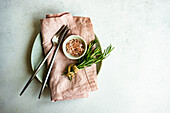 Minimalist cutlery set with fresh rosemary and himalaya pink salt on concrete table